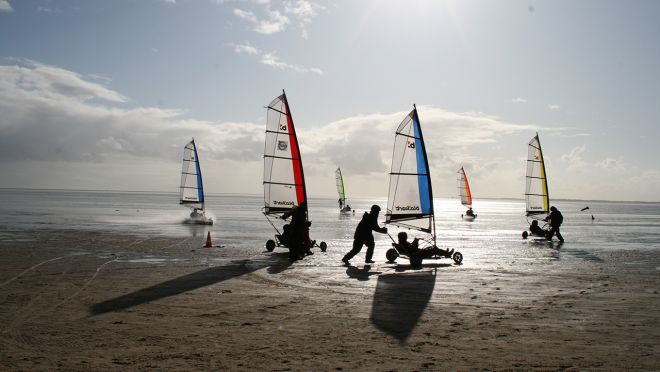 Mit Kite-Buggys gemeinsam am Strand entlang.