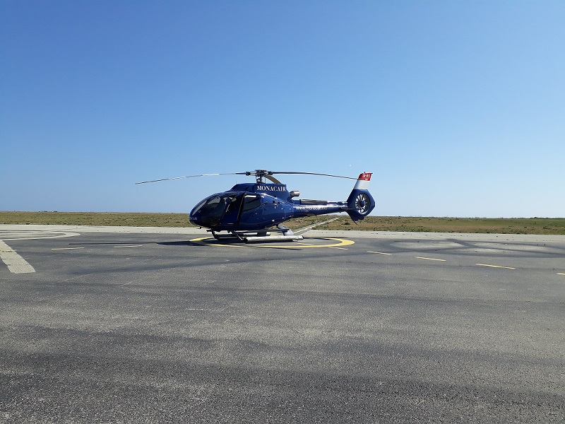 Ein blauer Hubschrauber steht auf dem Landeplatz